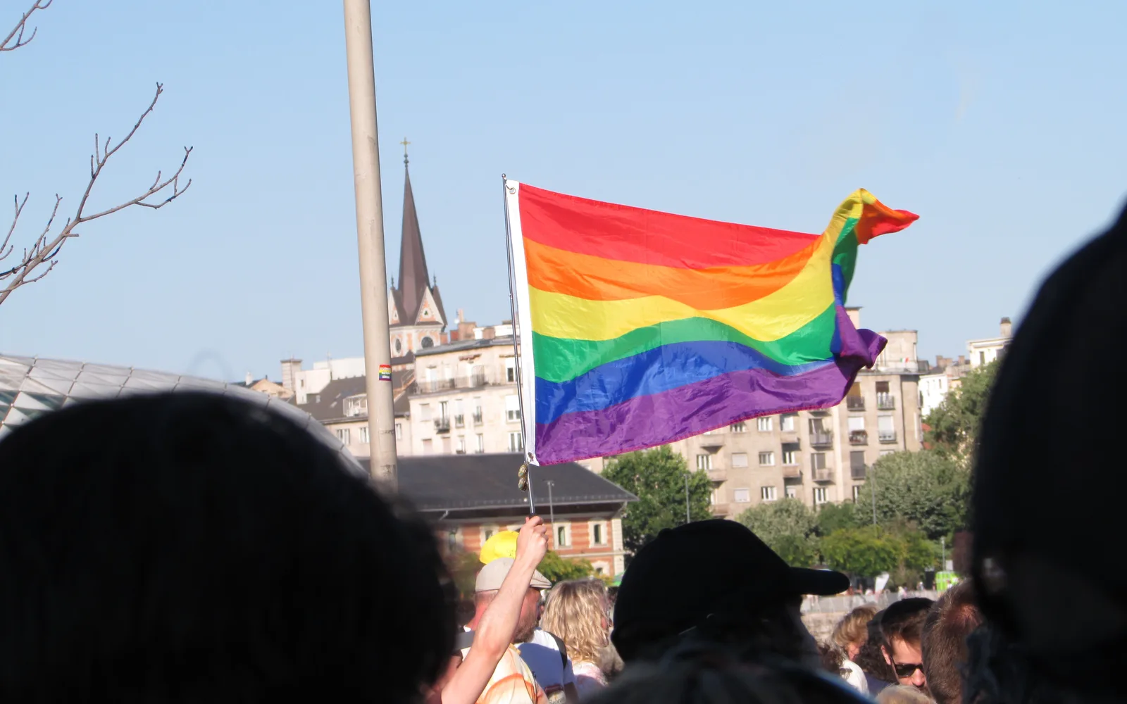 A rainbow pride flag being waved at the 2025 Budapest Pride celebration